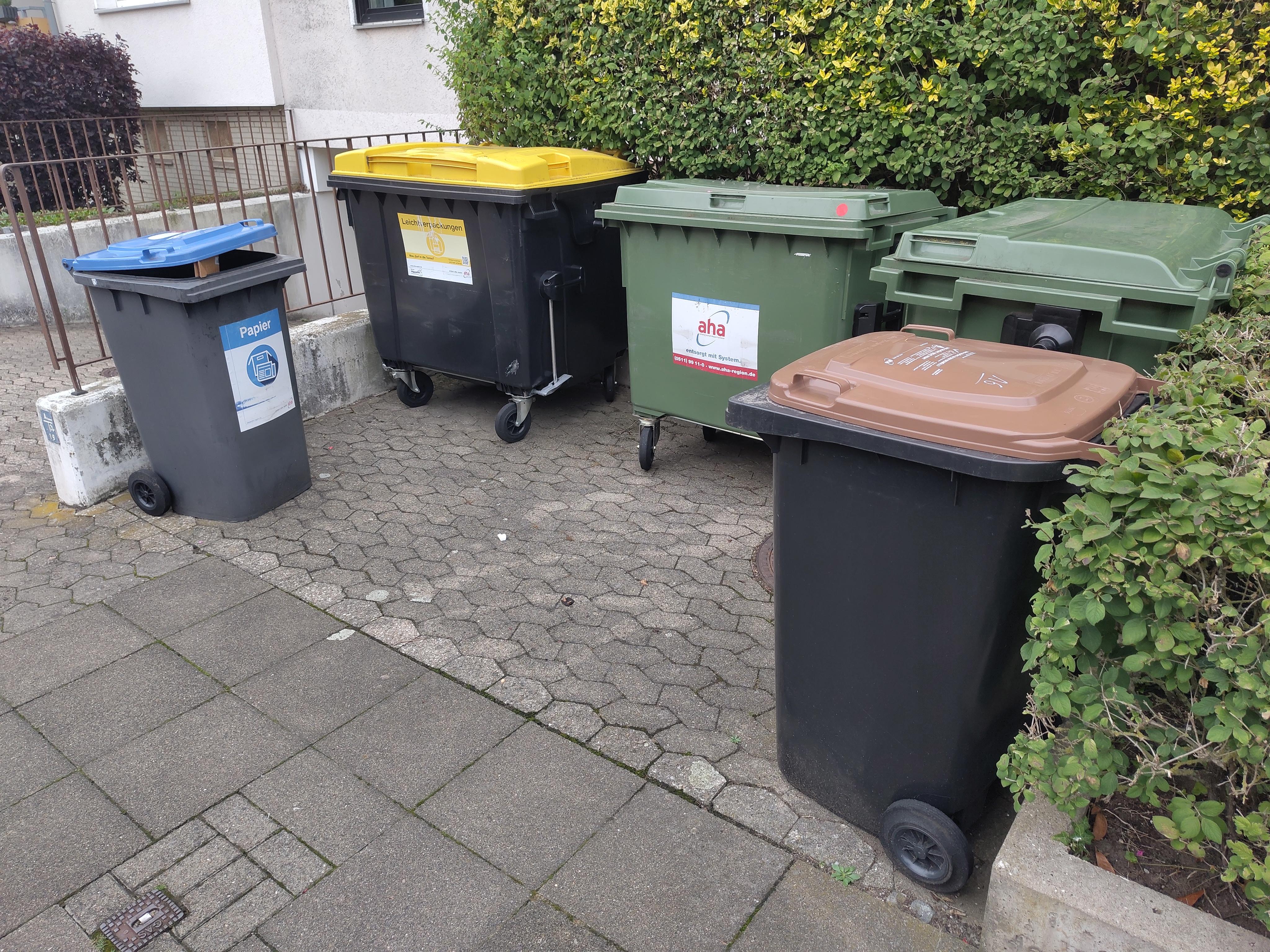 Überfüllte Papiertonnen vor einem Mehrfamilienhaus in Hannover